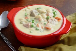 Chicken pot pie soup postpartum freezer meal in a red glass bowl